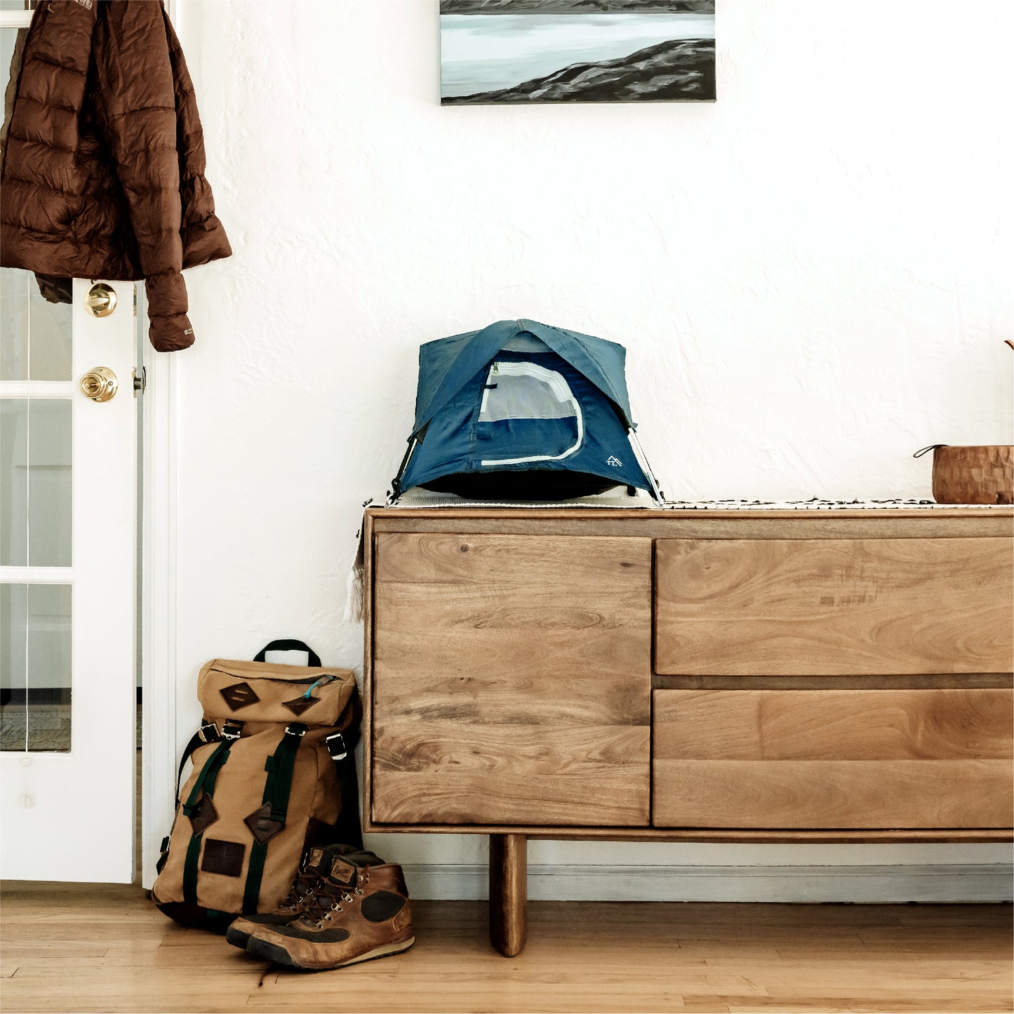 blue tiny tent shown in a home entryway with jacket, shoes, and backpack in image