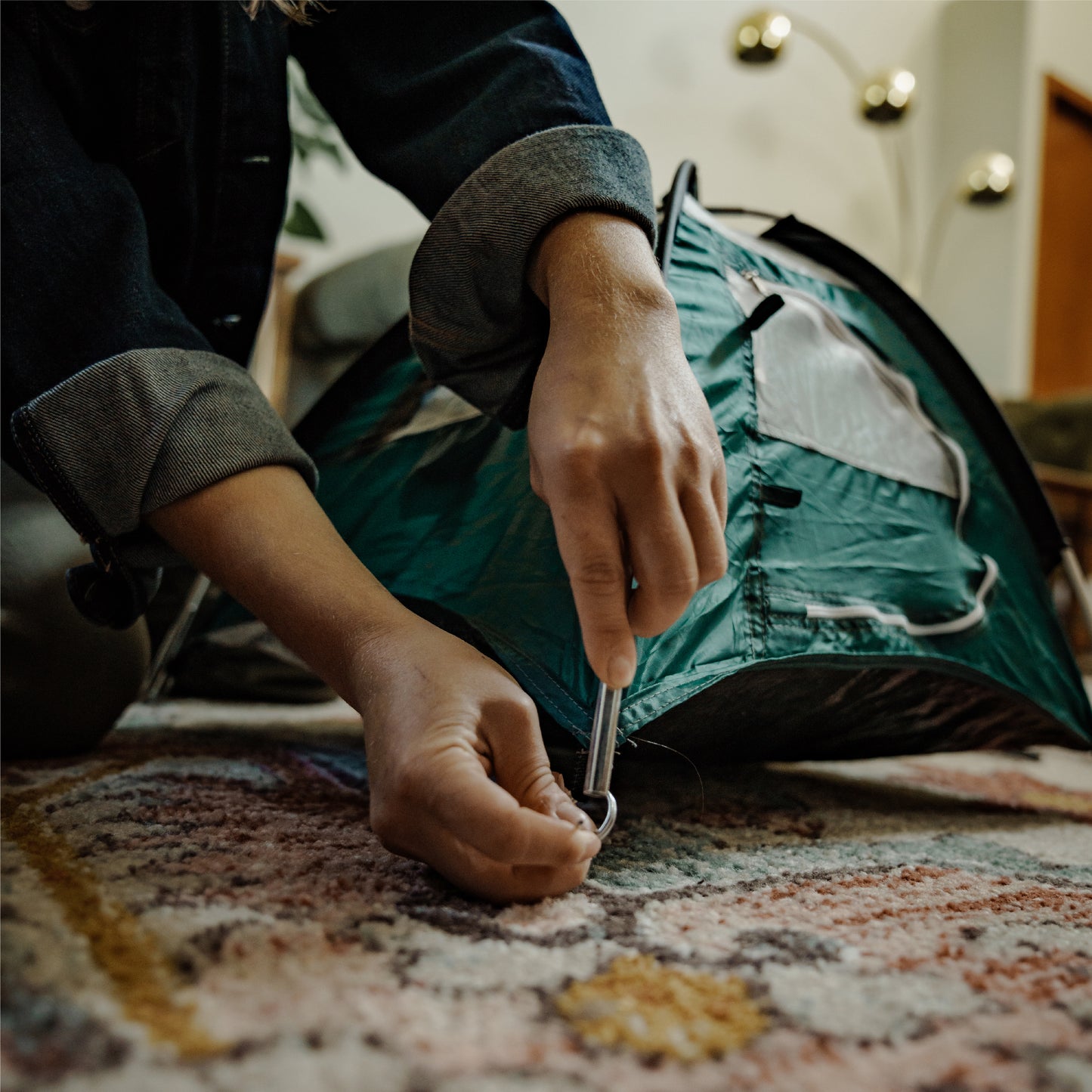 Green tiny tent being assembled, showing how the corner is assembled.