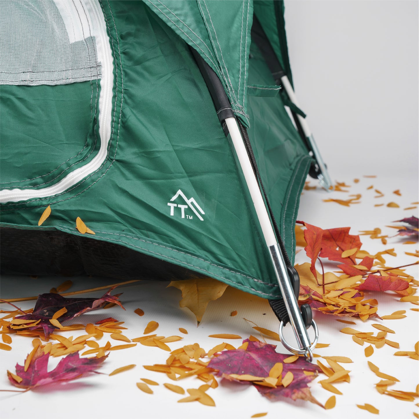 green tiny tent detail of the corner assembly. Leaves in the foreground.