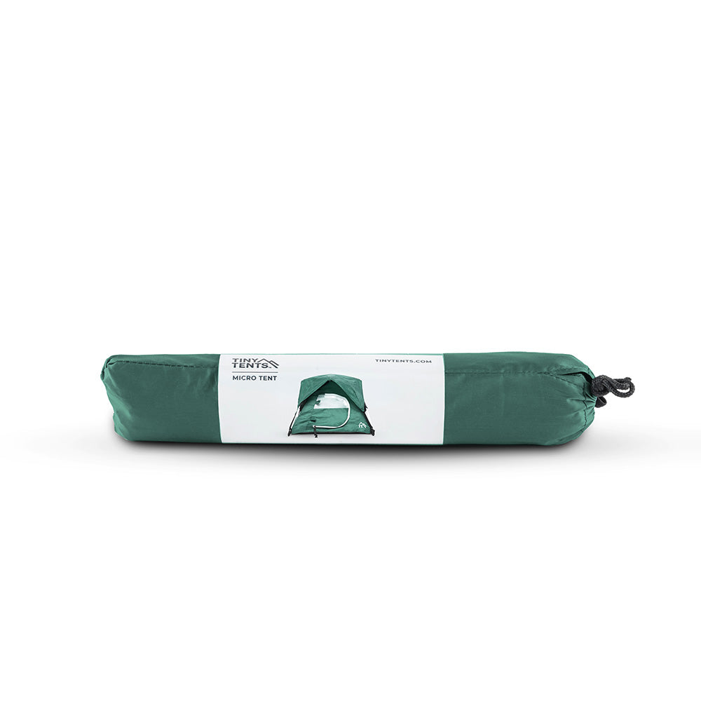 Packed up alpine green micro tent on white background